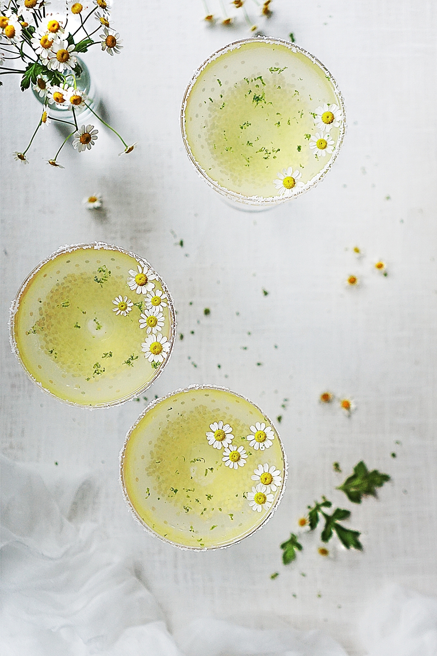 Three Chamomile Tequila Sour with chamomile flowers as garnish