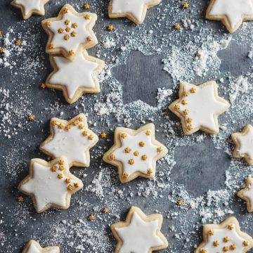 Sugar cookies in shape of stars on a gray backdrop