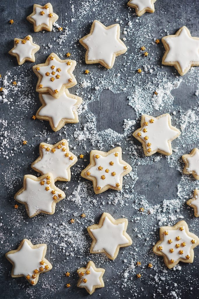 Sugar cookies in shape of stars on a gray backdrop