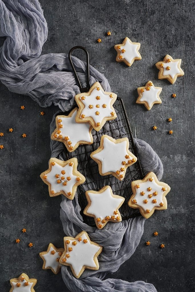 Star shaped cookies with white glaze on a cookie tray