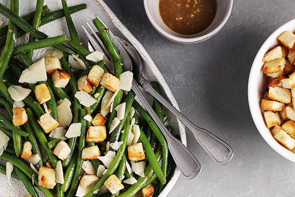 Green Bean Salad on a plate with salad dressing & croutons