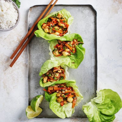 Four lettuce wraps on top of a metal tray.