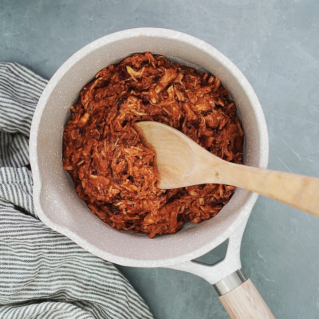 A small saucepan with shredded chicken and chipotle sauce