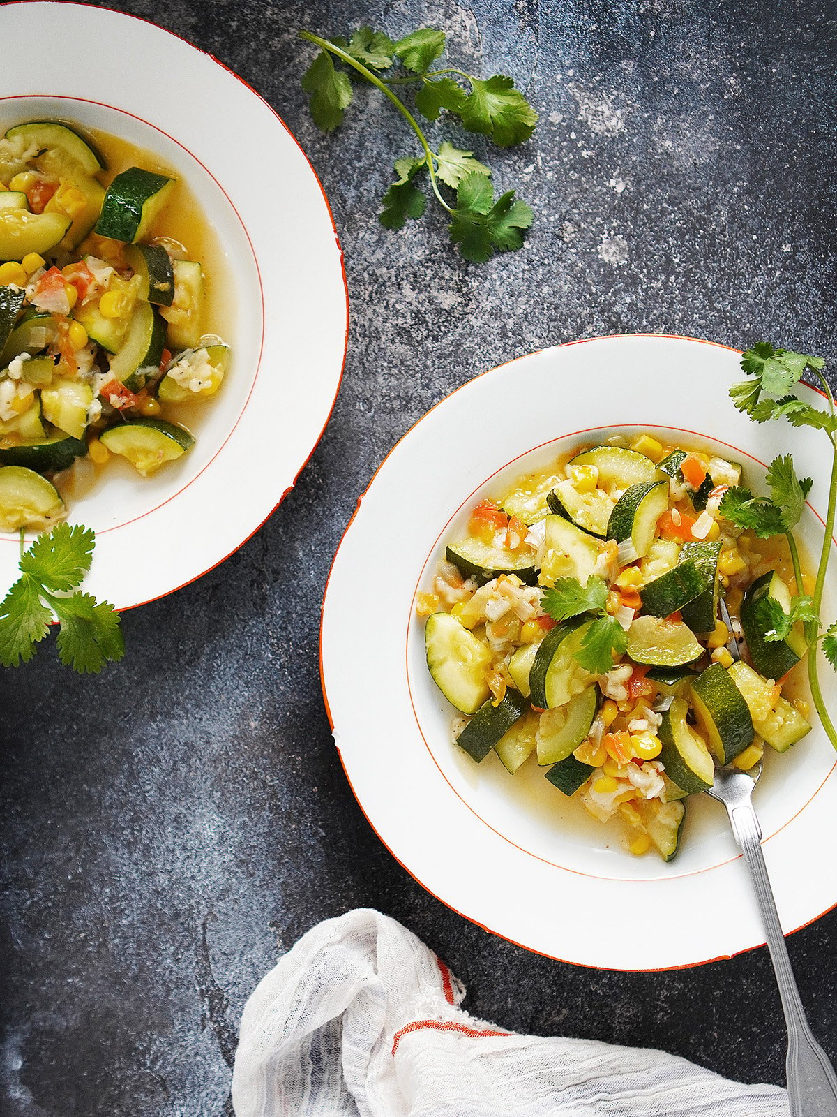 Two white bowls with Calabacitas (Mexican Zucchini dish)