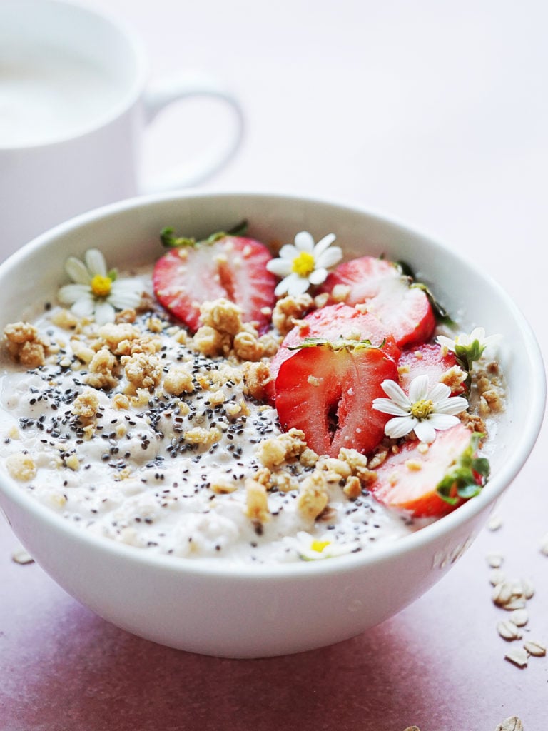 A bowl filled with Greek yogurt and oats topped with strawberries