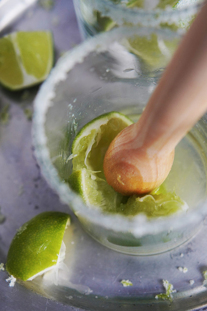 Grinding limes for the juice in a clear glass