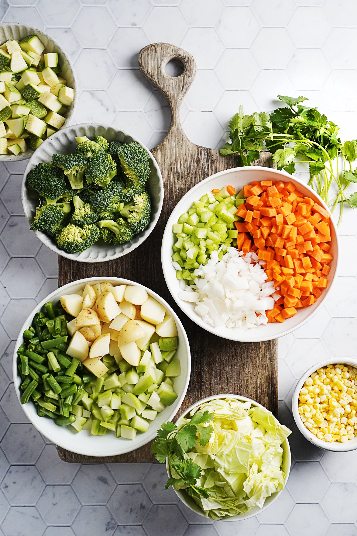 Cut vegetables placed on bowls on a cutting board