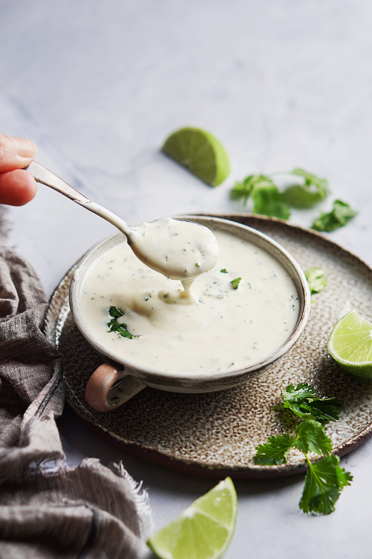 A spoon with dripping Mexican Crema