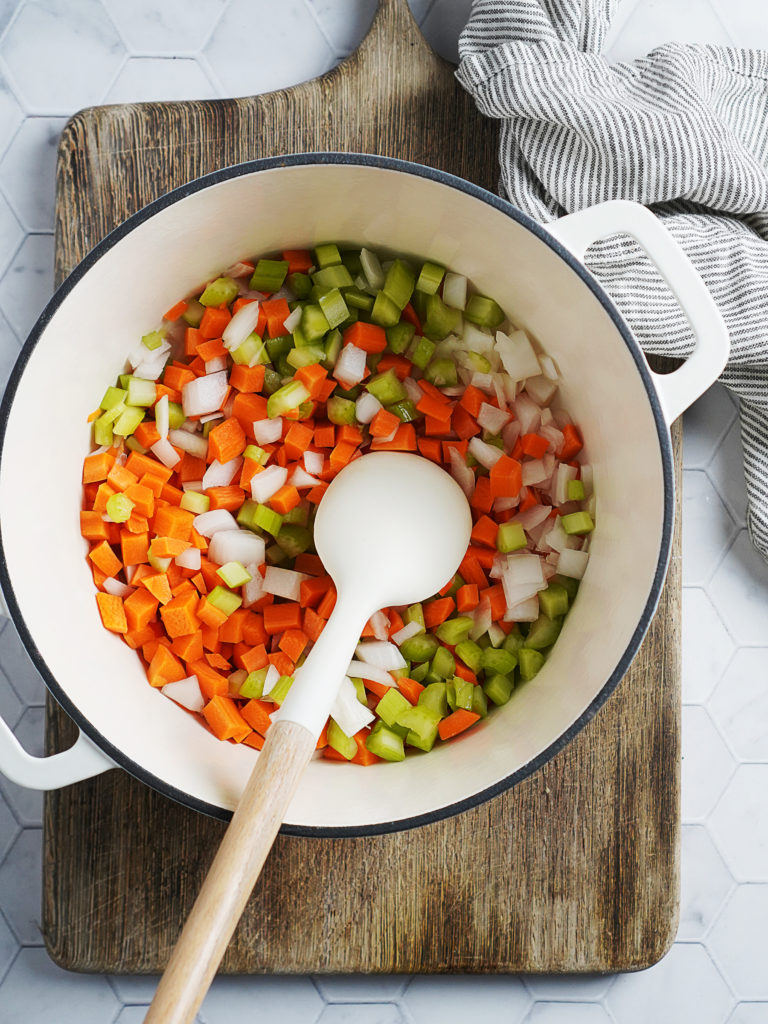 Sauteing carrots, celery and onions in a large pot