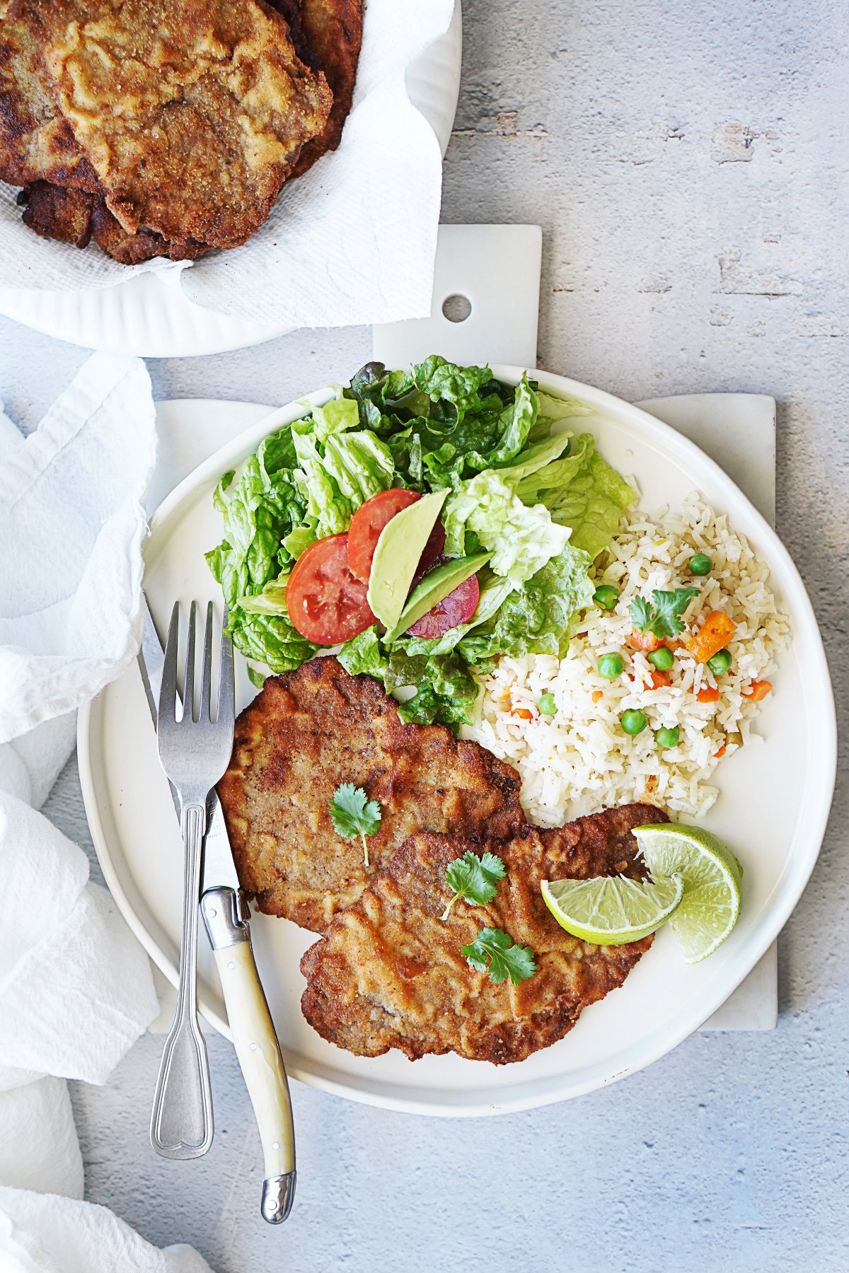 Milanesa on a plate with salad and rice on the side