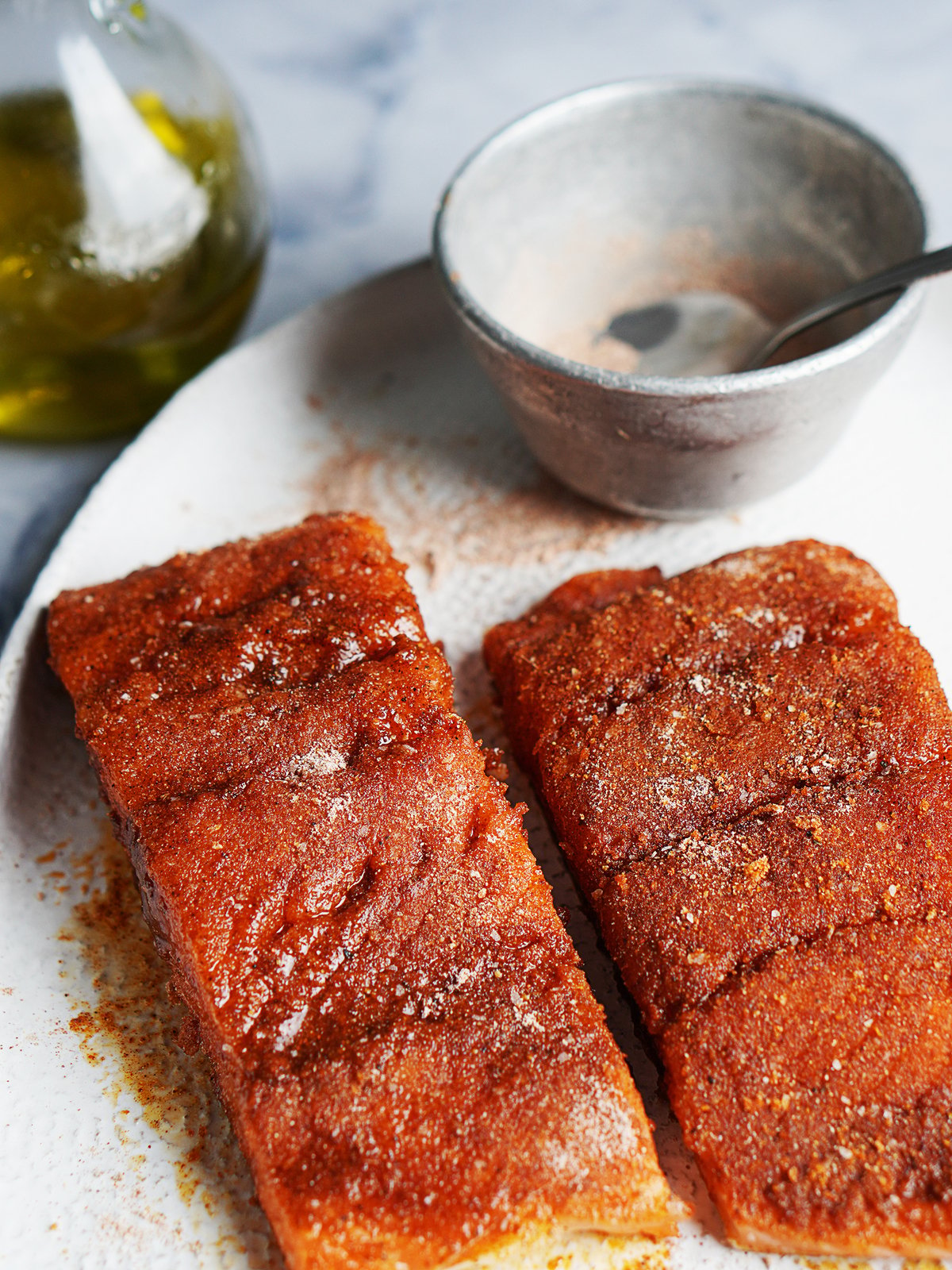 Close up image of two slices of salmon filets with spice rub on top