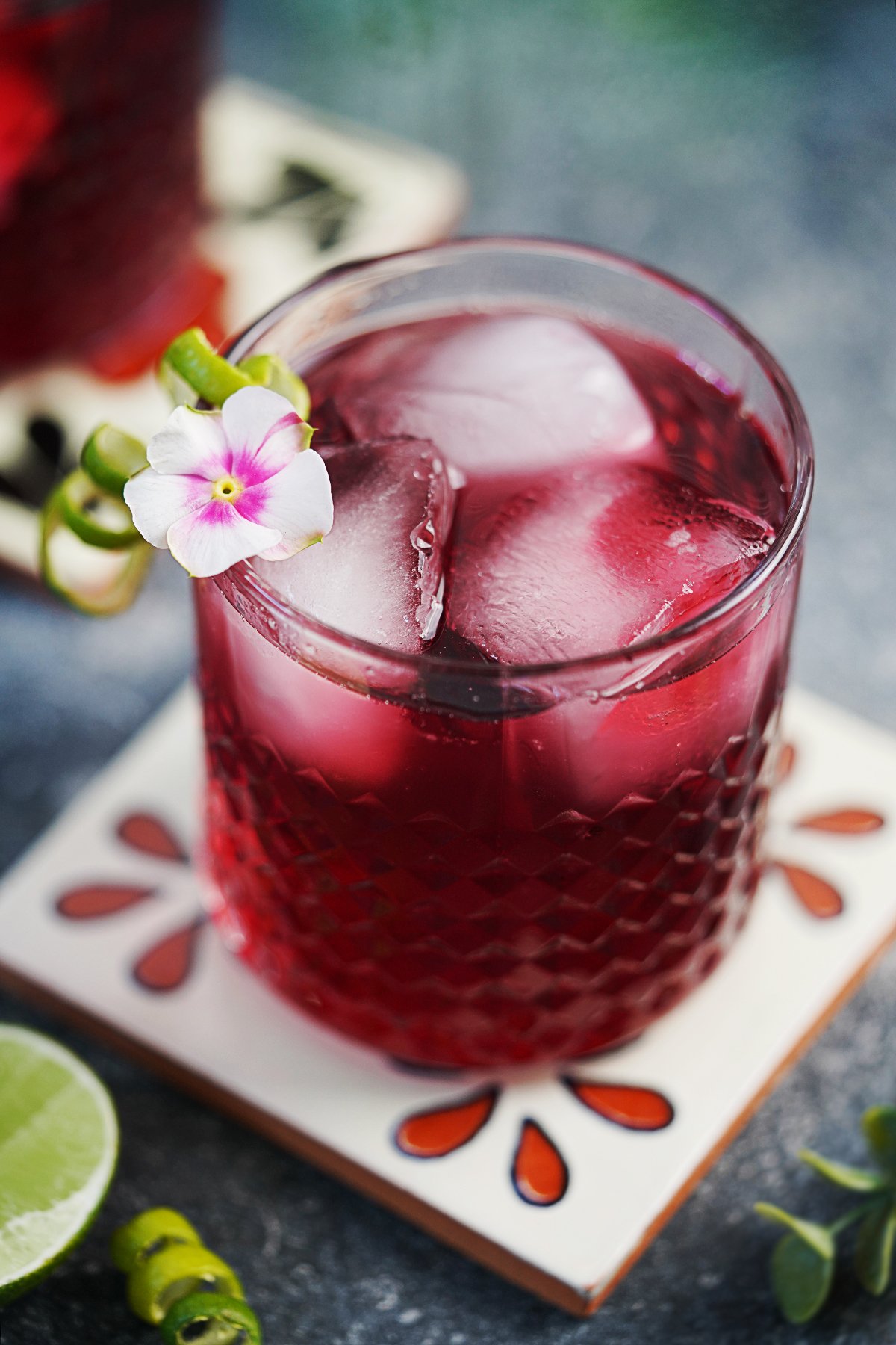 A glass with Hibiscus Margarita and large ice cubes. 