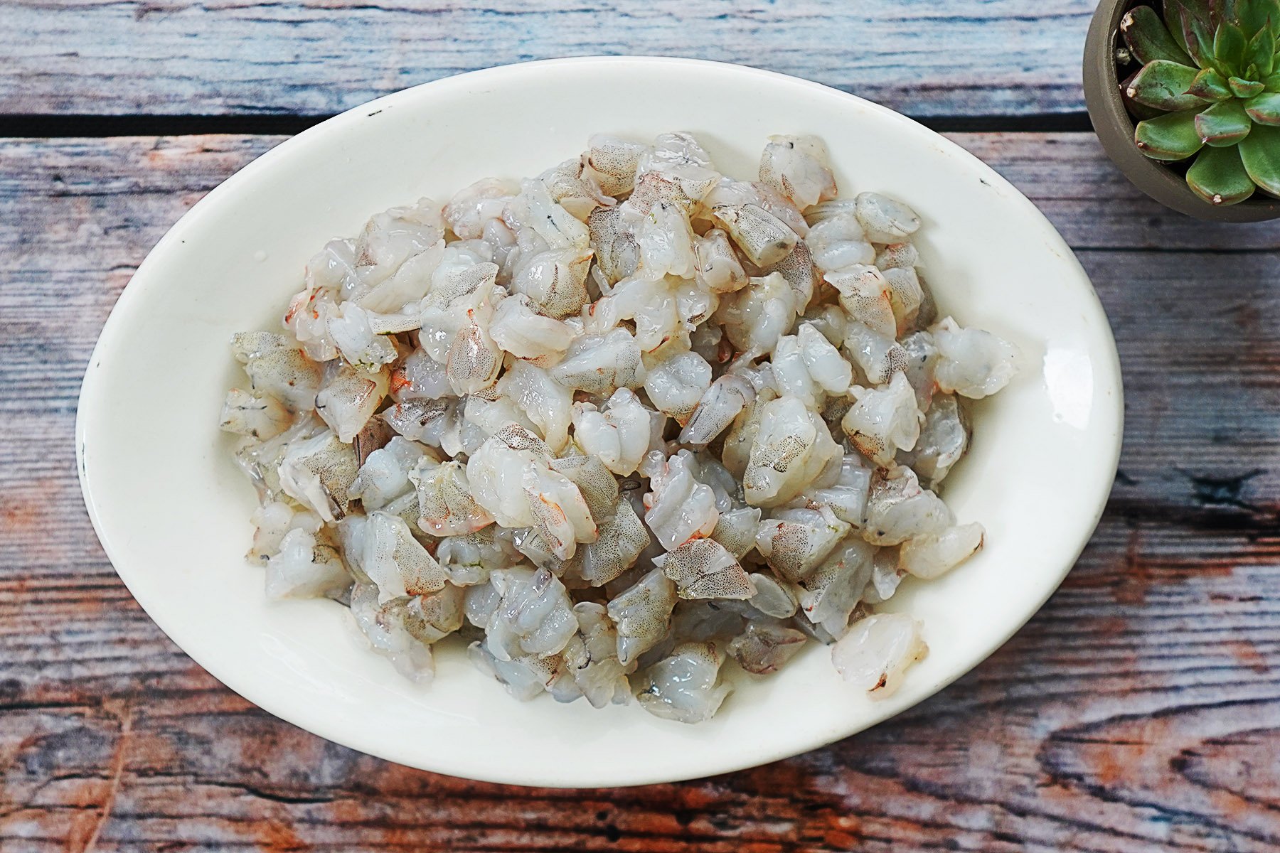 Chopped raw shrimp on a white oval plate