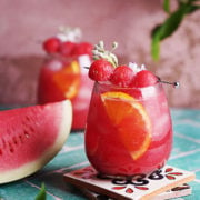 Cocktail glass with red sangria in it on a green table