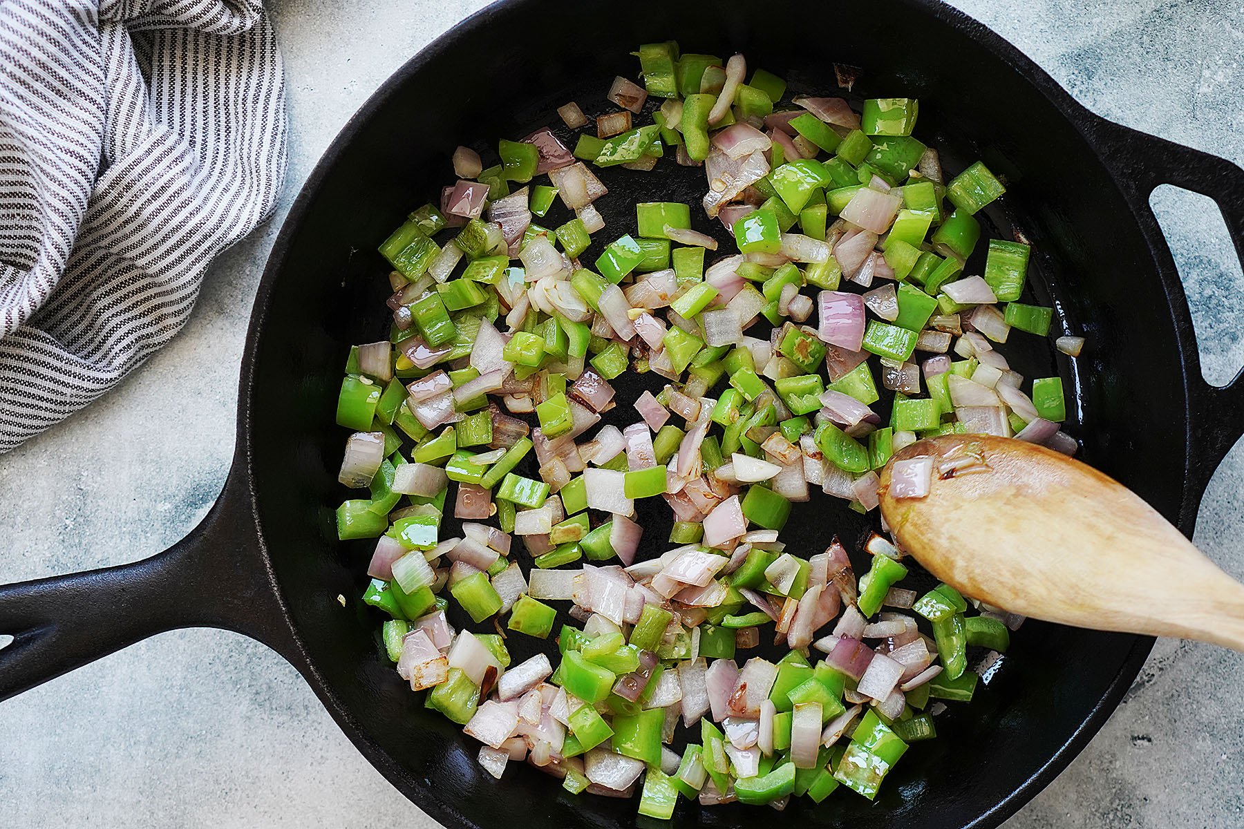 Sautéing onions and green peppers on an iron skillet