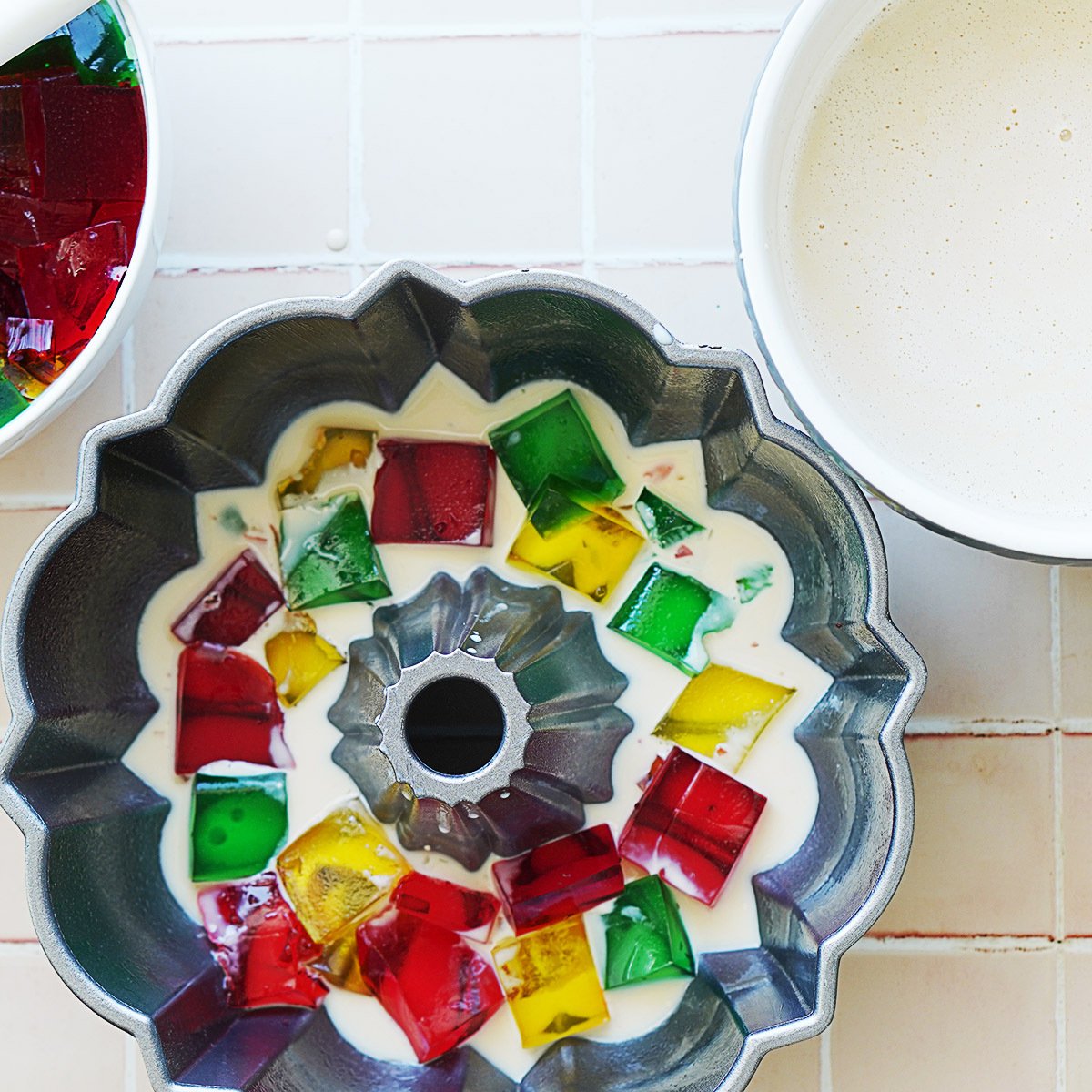 A bundt cake mold with jello squares and a milk mixture
