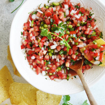 Pico De Gallo Salsa on a white bowl with tortilla chips on the side