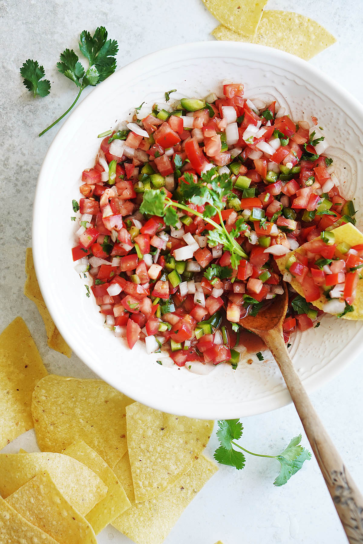 Pico De Gallo Salsa on a white bowl with tortilla chips on the side