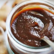 Tamarindo Paste in a small glass jar with a spoon in it.