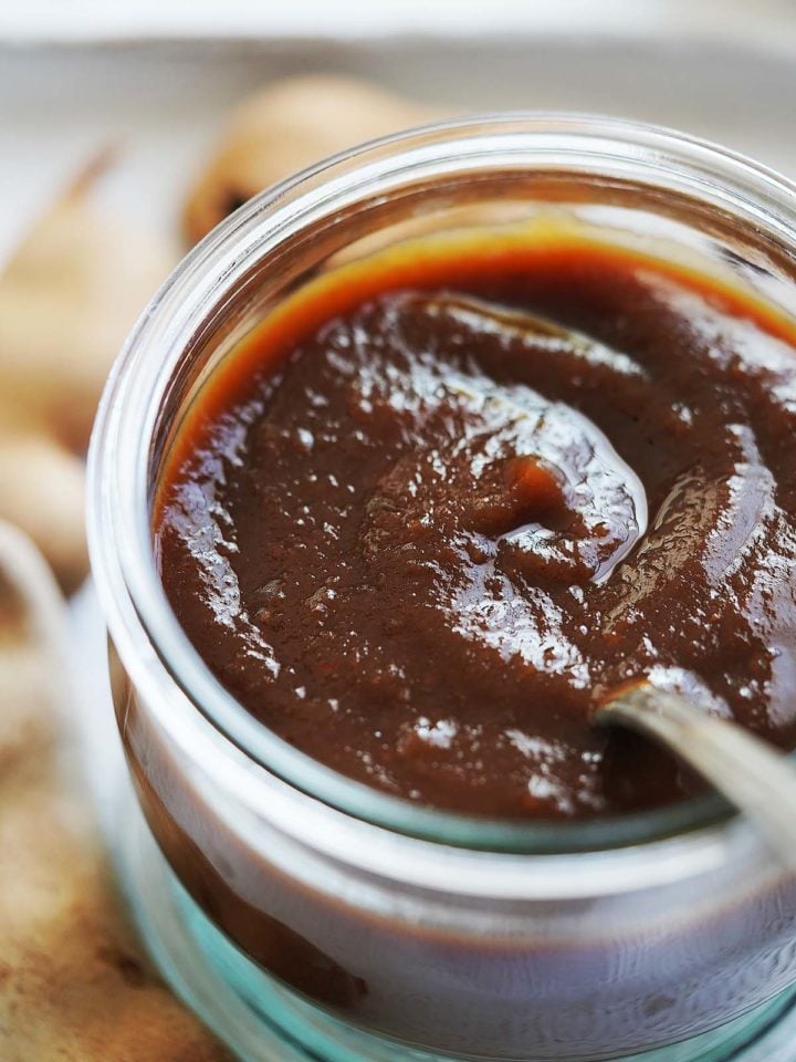Tamarindo Paste in a small glass jar with a spoon in it.