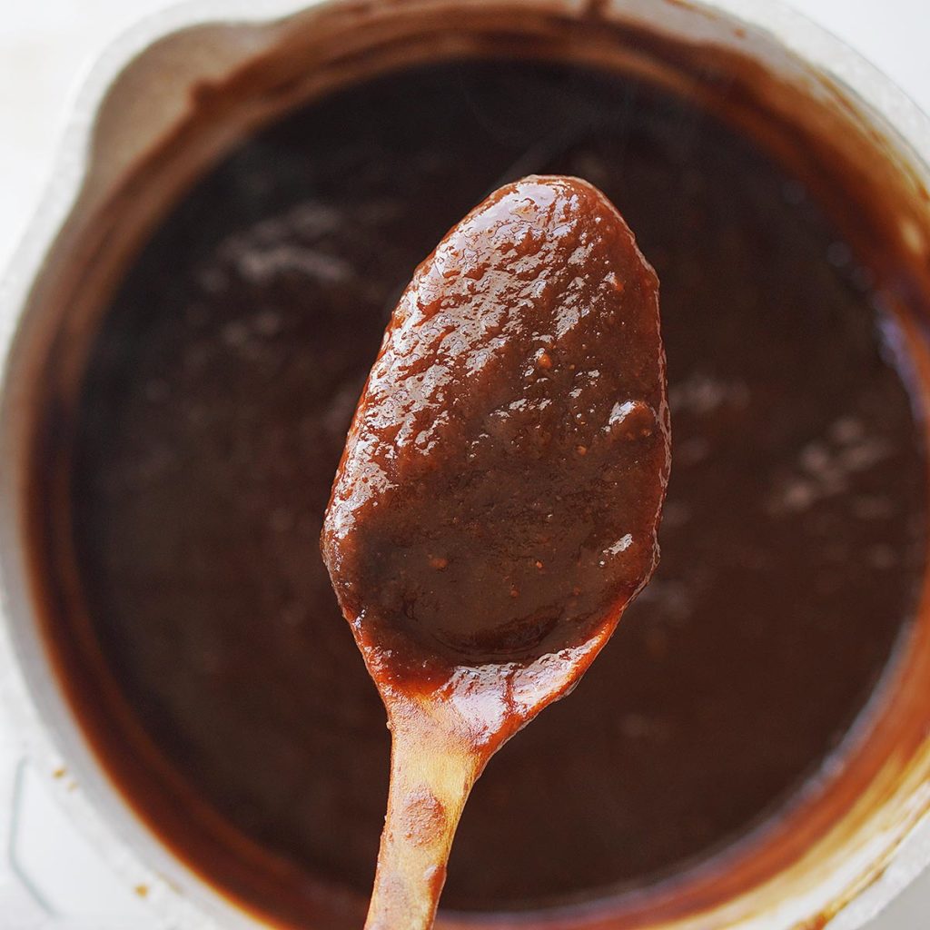 A spoon with the brown paste.