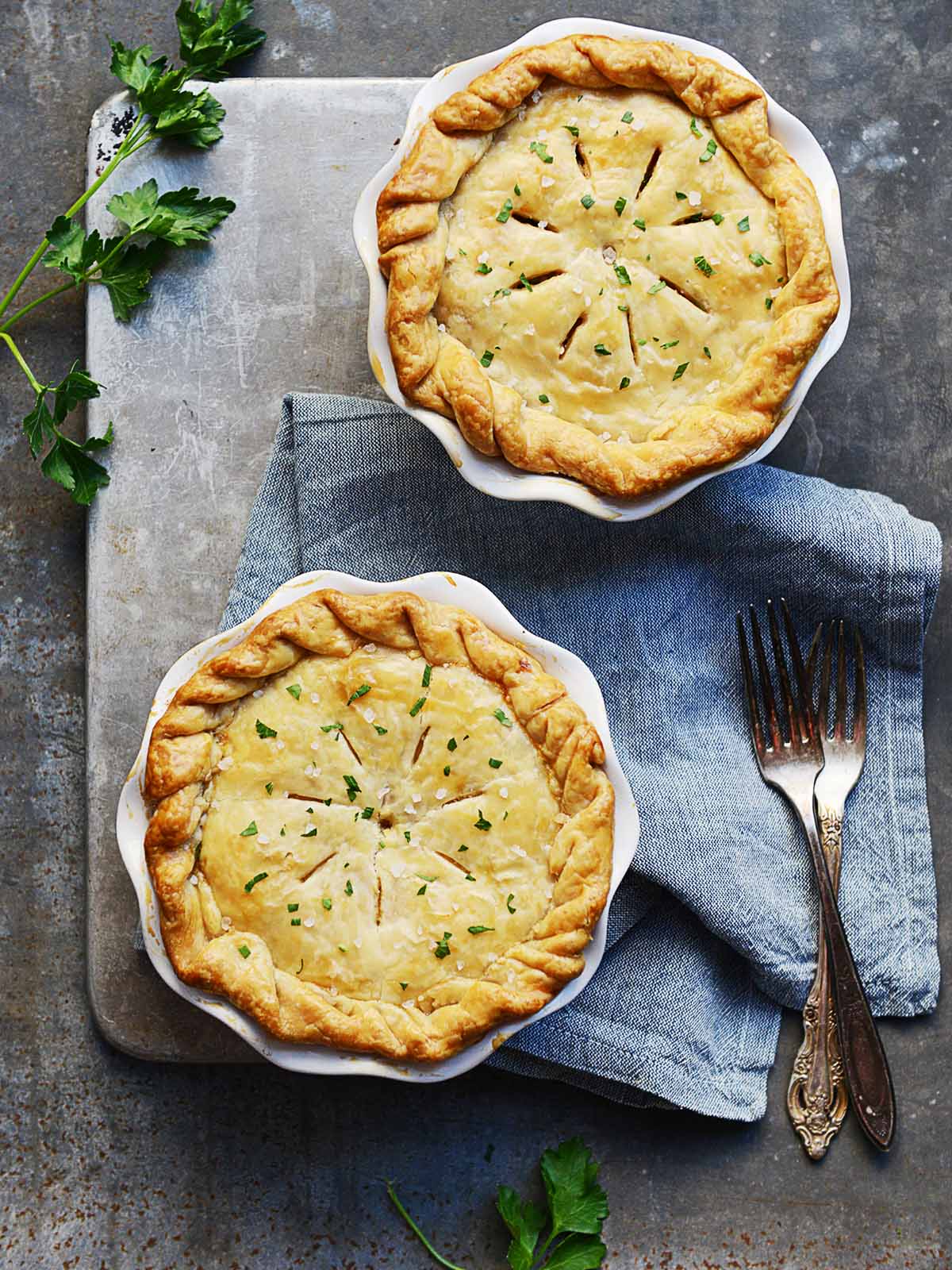 Two pot pies with forks on the side.