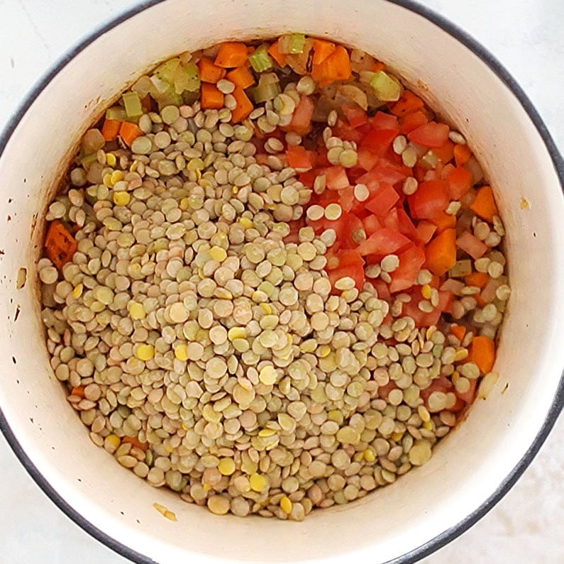 A saucepan cooking lentils and vegetables.
