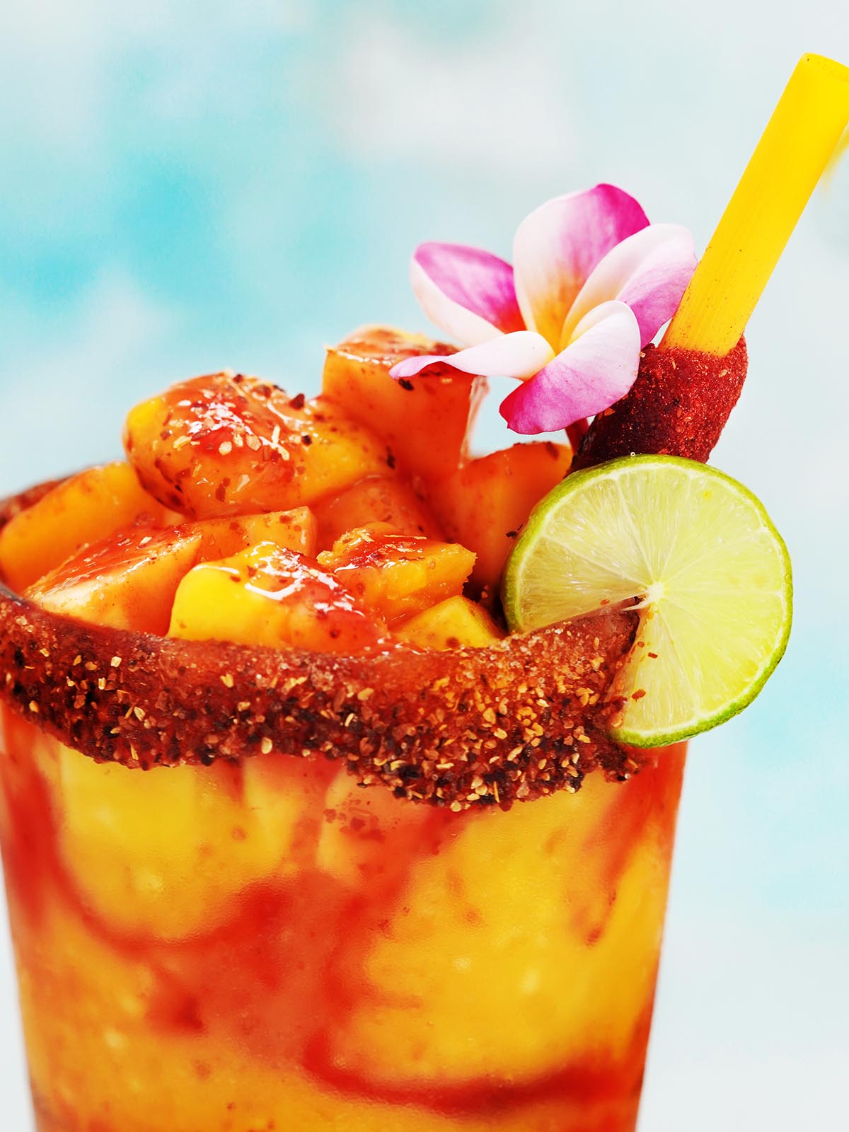 A glass with mangonada drink decorated with a flower. 