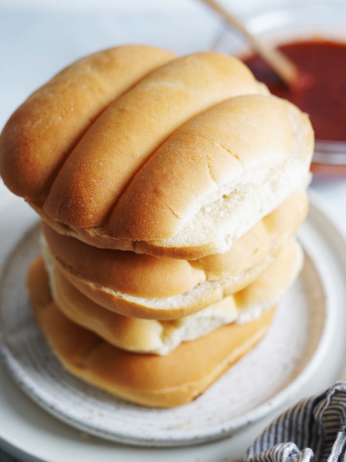 A stack of telera bread on a white plate.
