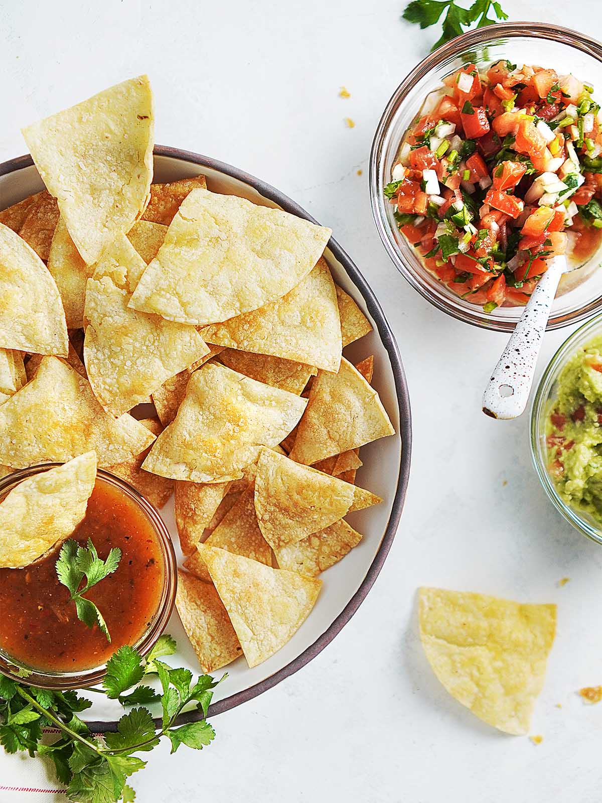 A bowl with totopos chips and salsa on the side.