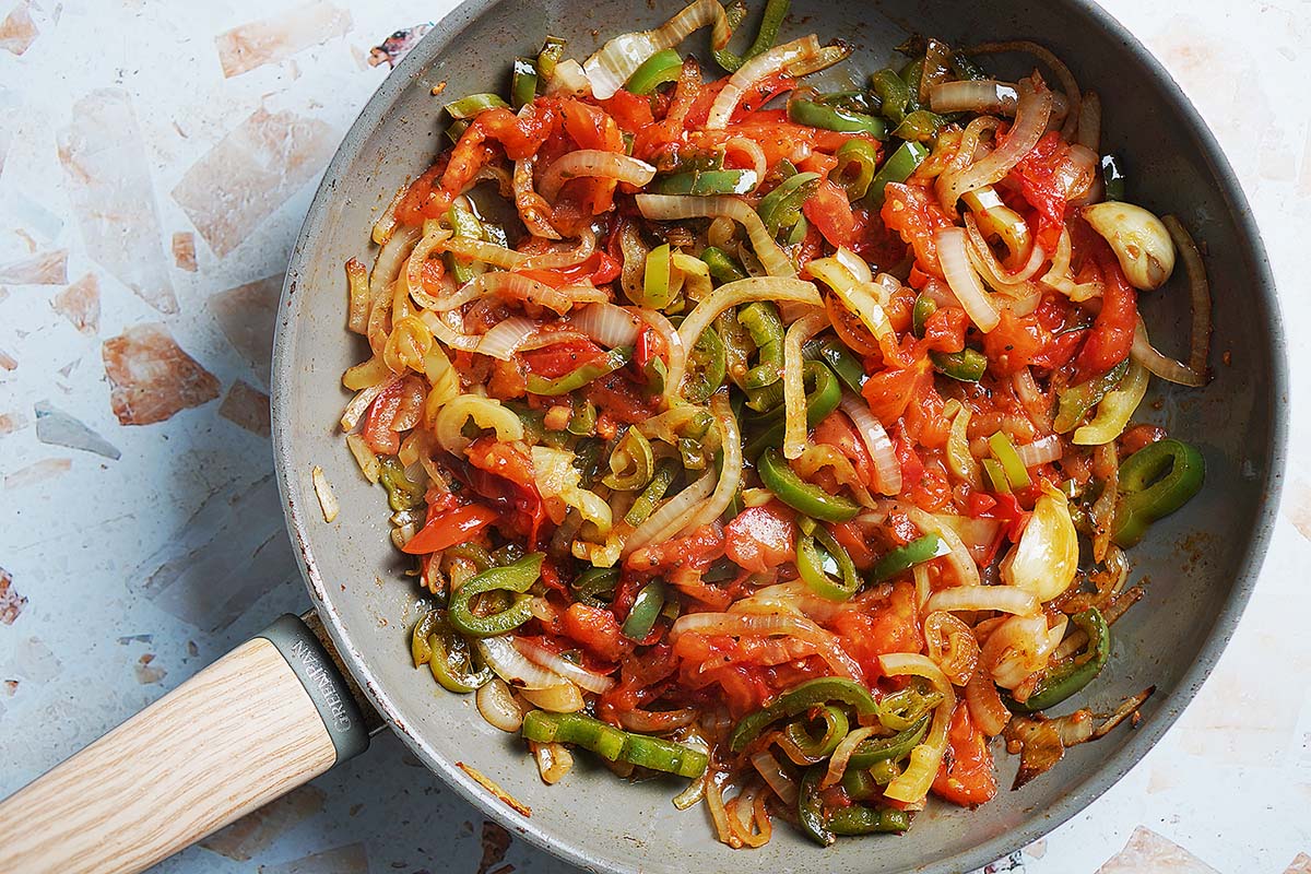 A skilled with sauteed onions, green peppers and tomatoes.