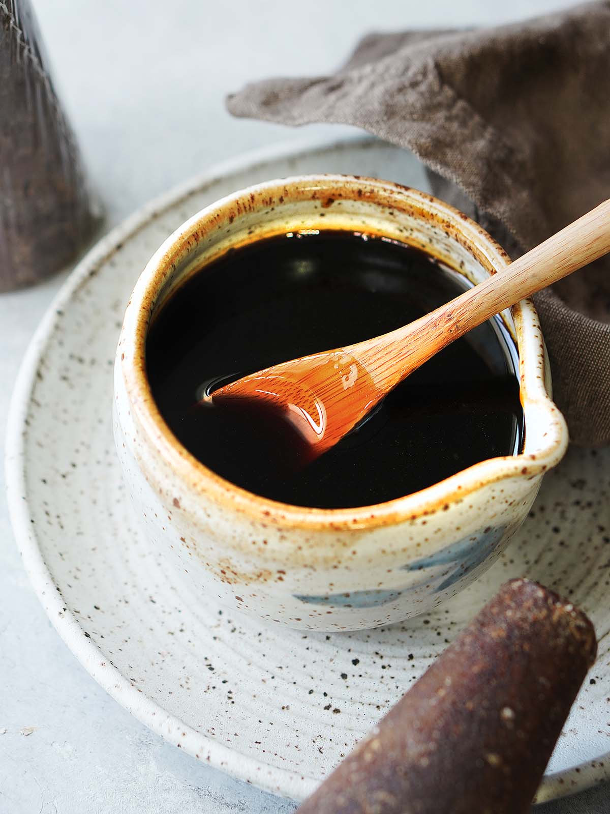 Piloncillo syrup in a small bowl with a wooden spoon.