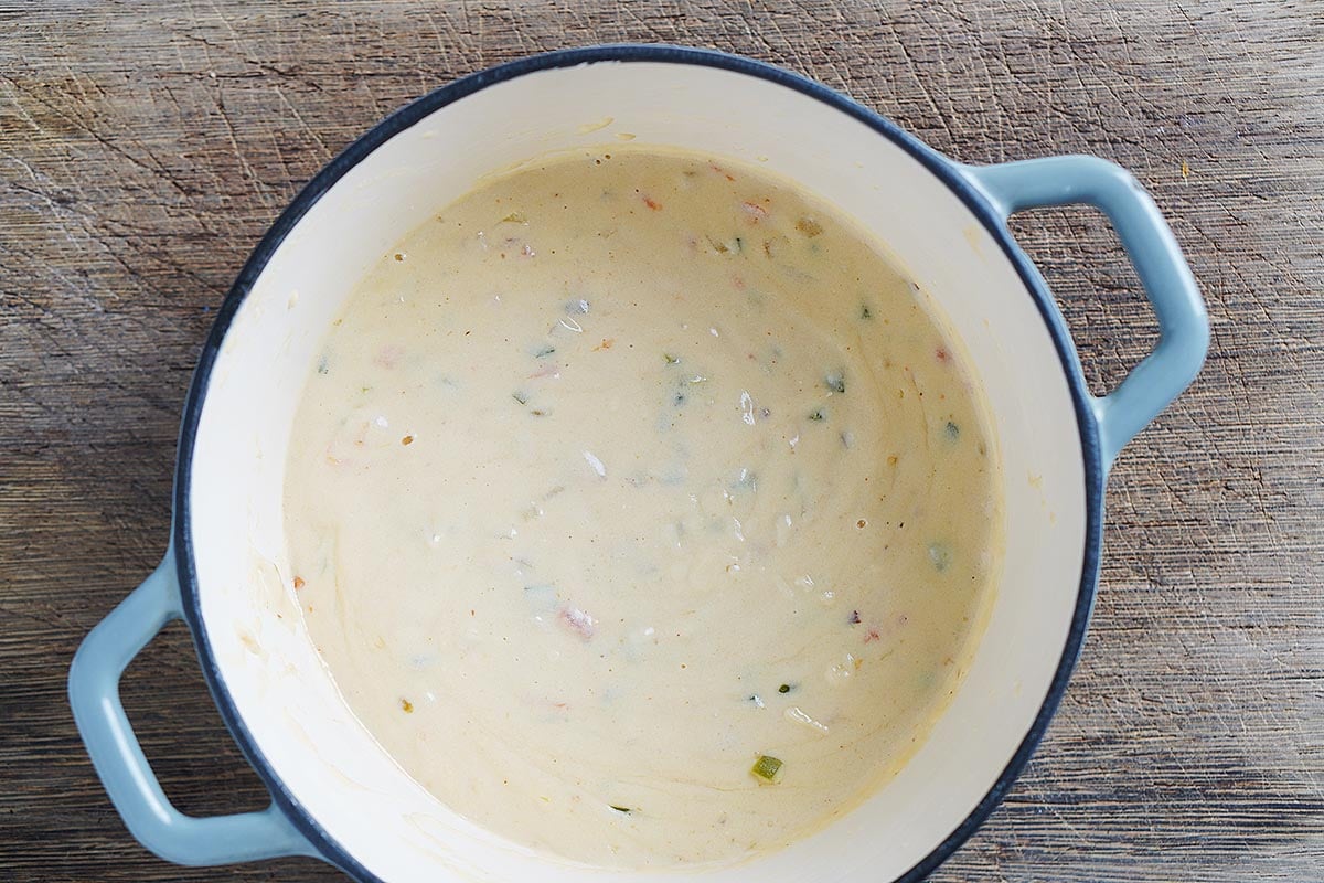 A saucepan with melted cheese dip in it.