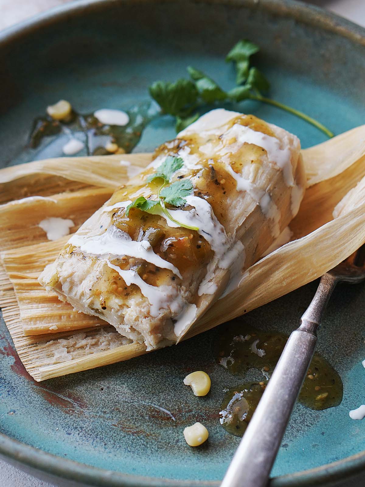 A green tamal placed on a corn husk.