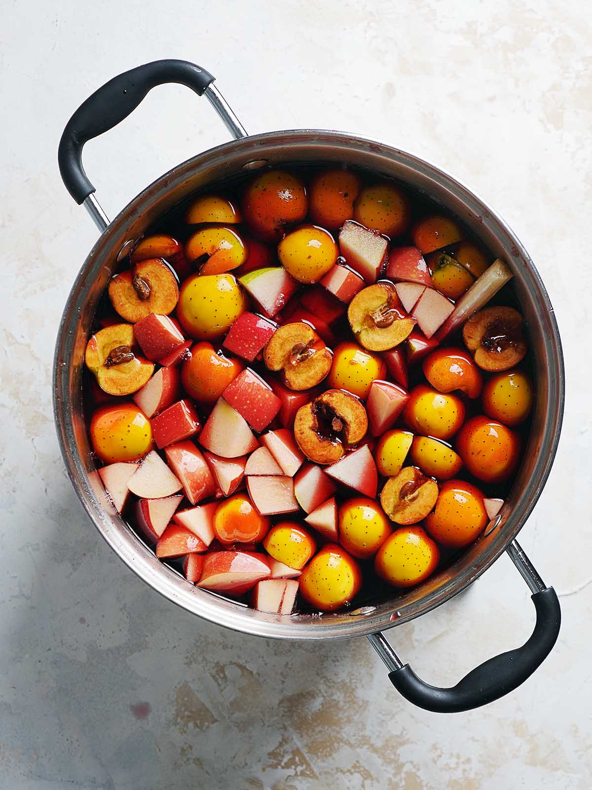 A large pot filled with fruit and punch.