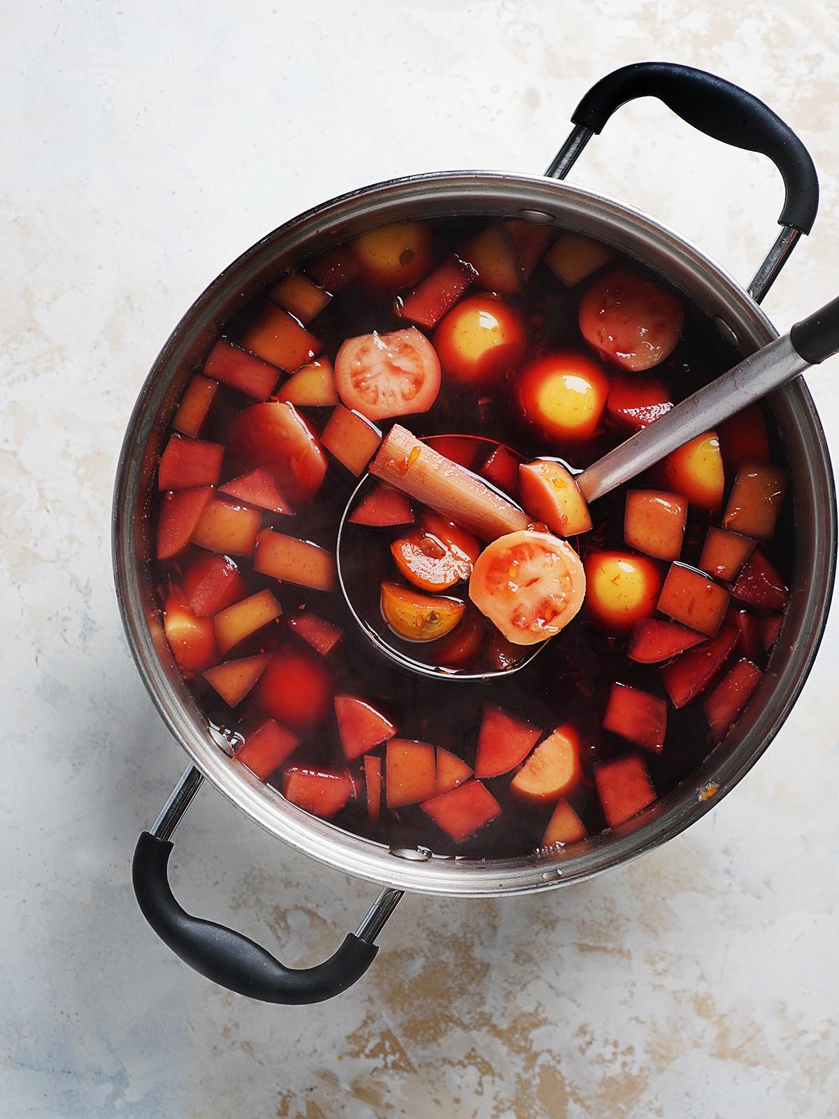 A large pot with punch and fruit.