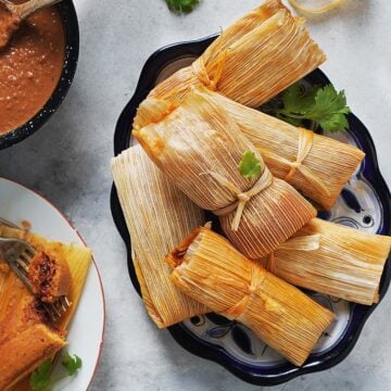 An oval plate with red tamales.
