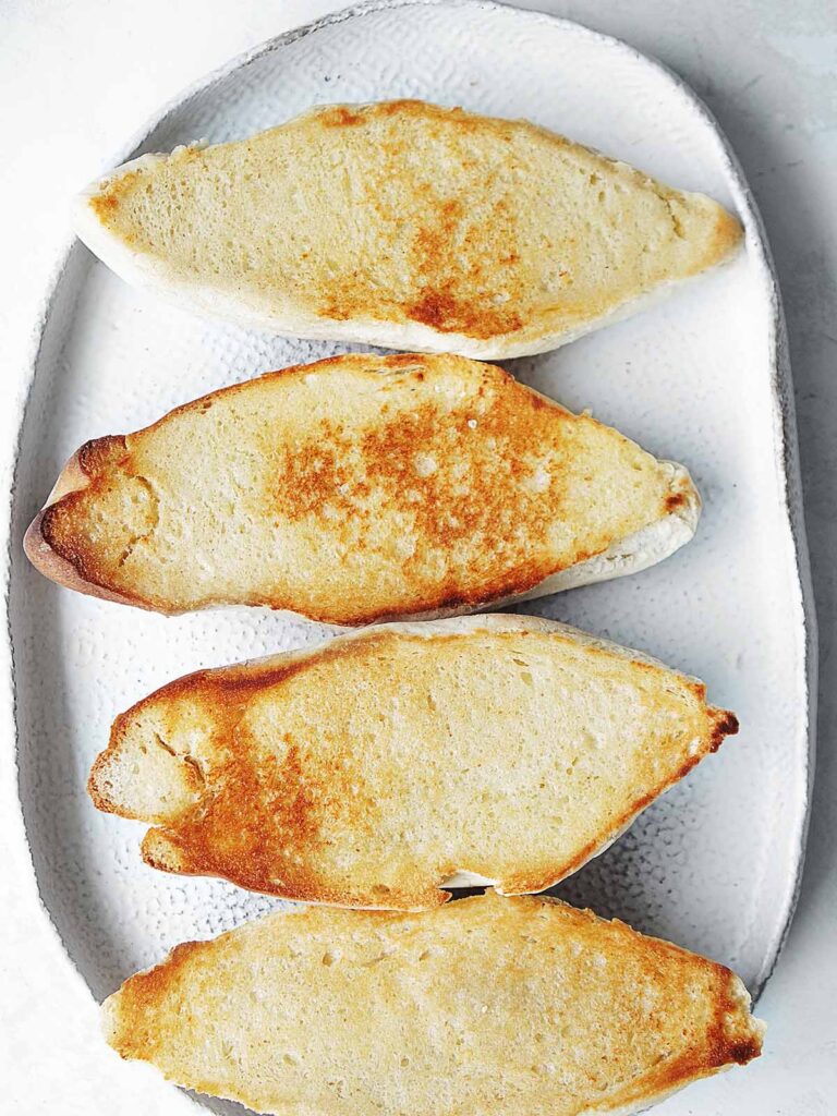 Four slices of bolillos toasted with butter.