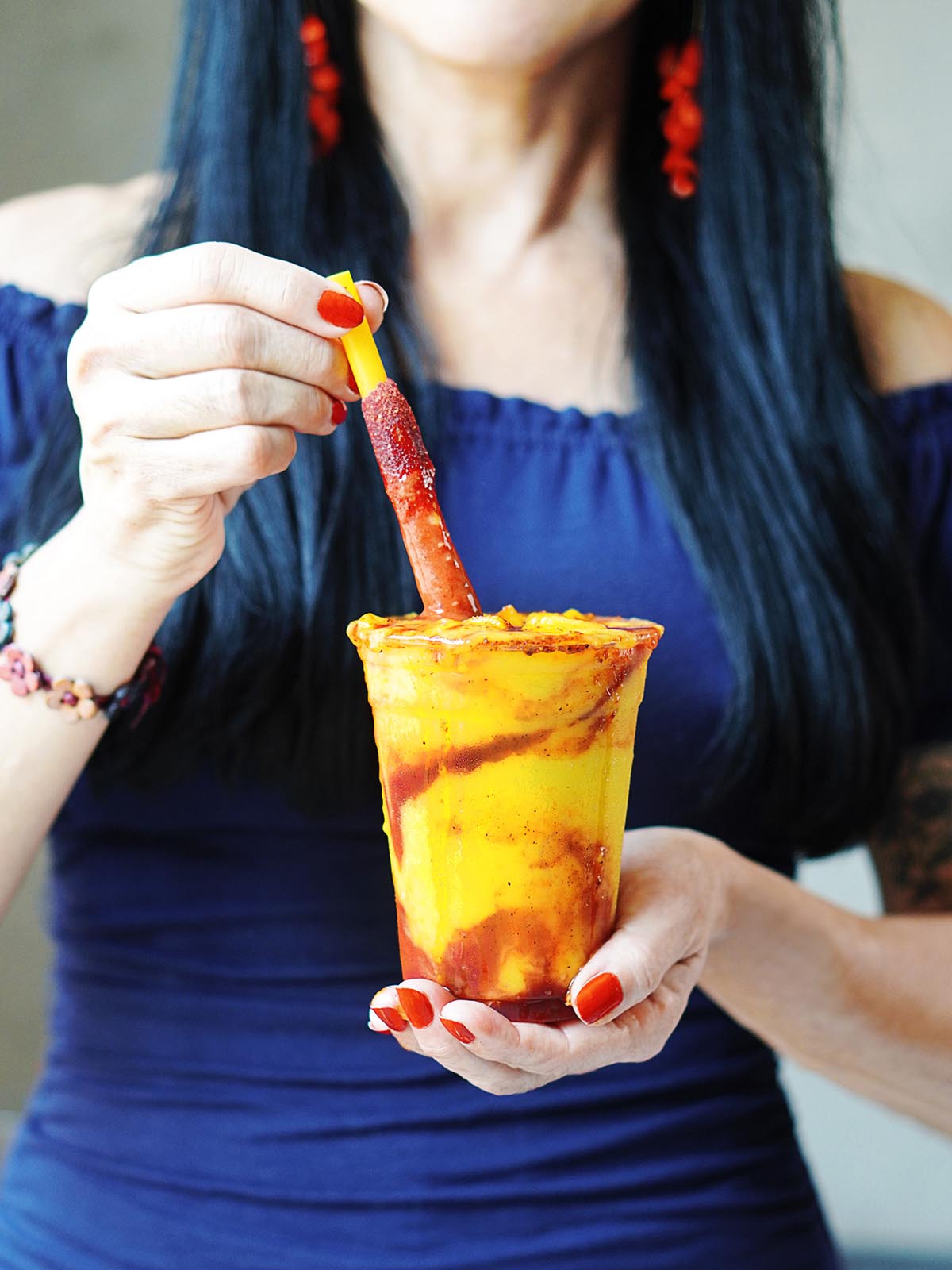 A person holding a mangonada with a hand.