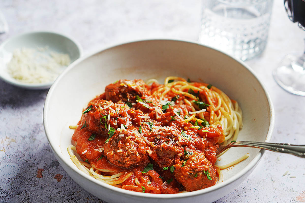A bowl with spaghetti and meatballs.