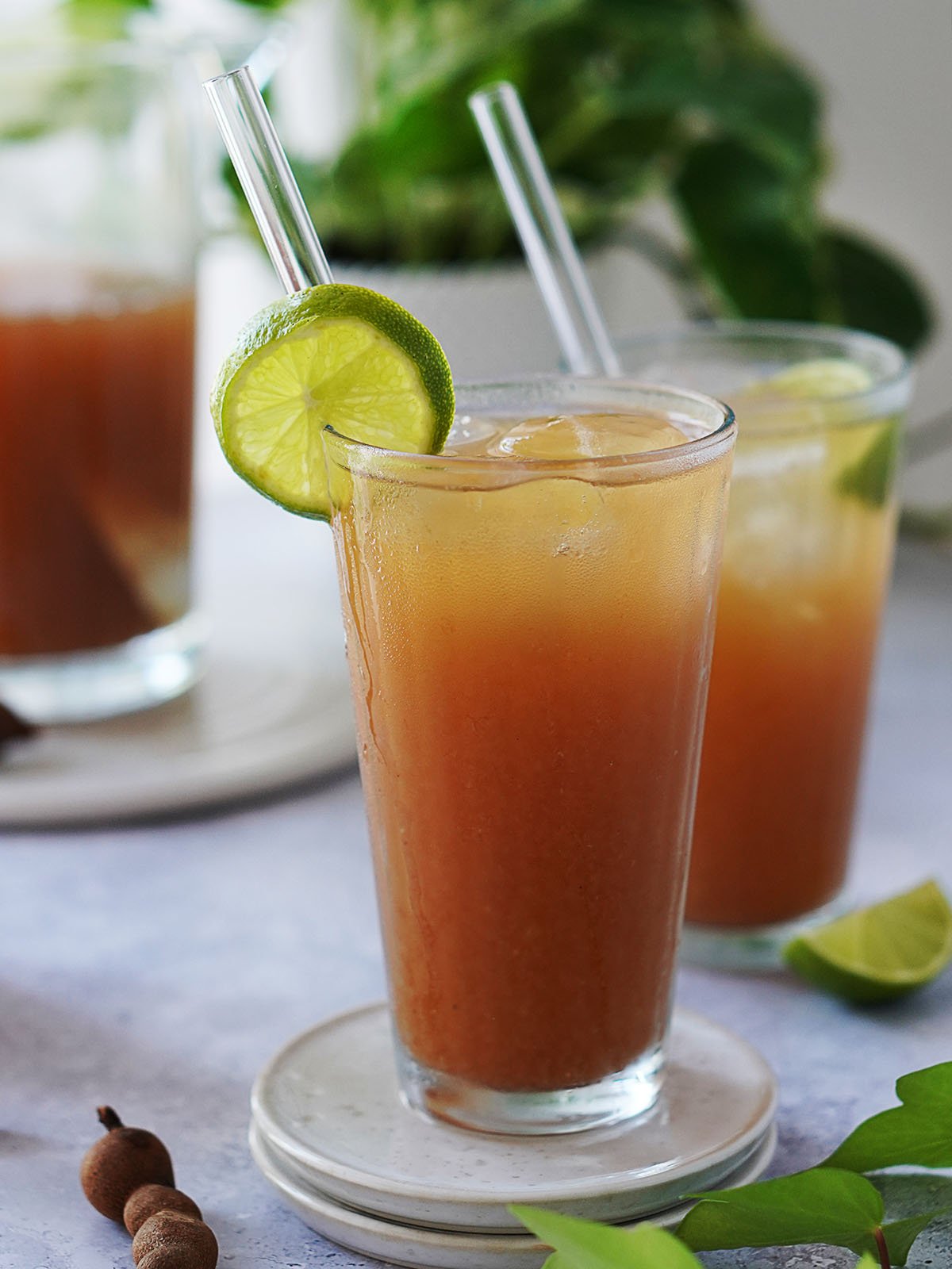 Two glasses with agua de tamarindo garnished a slice of lime.