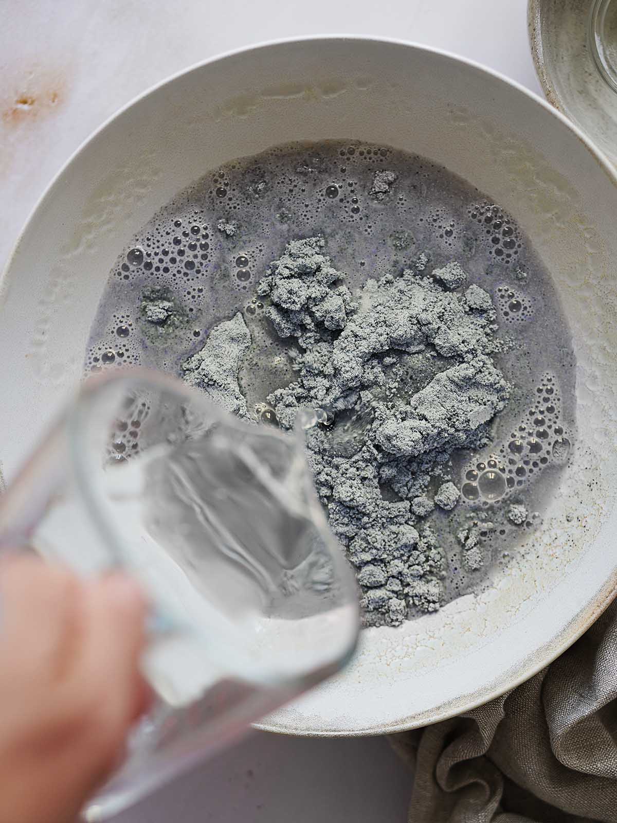 Pouring water into blue masa flour.