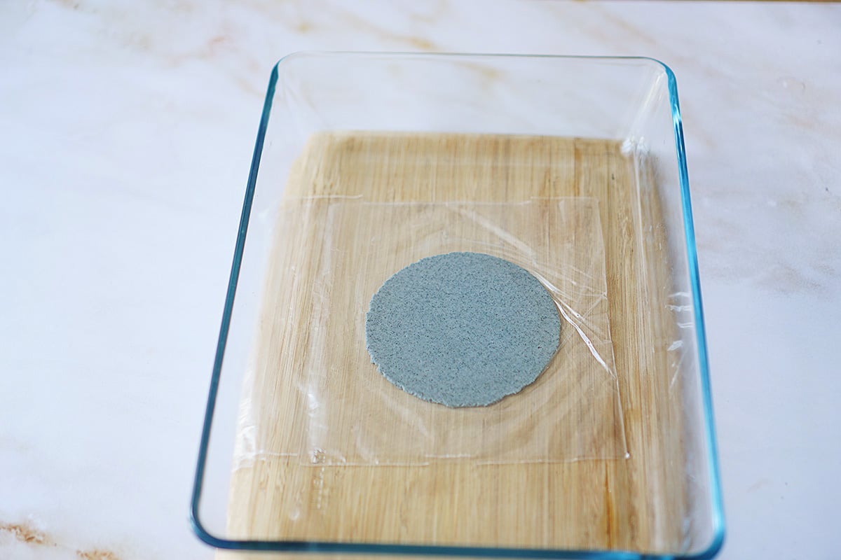 Pressing a tortilla with a glass clear baking dish.