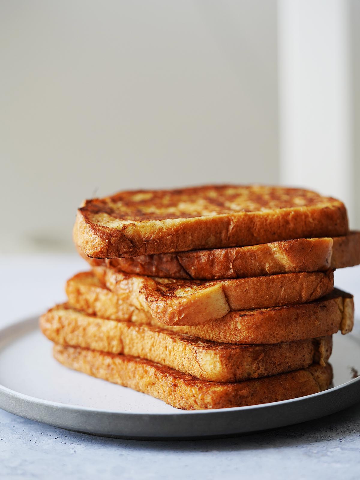 A stack of french toast on a white plate.