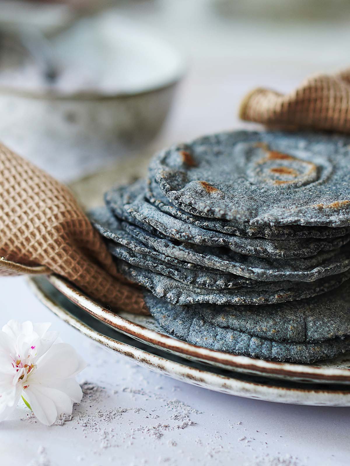 A stack of blue corn tortillas placed on a kitchen towel.