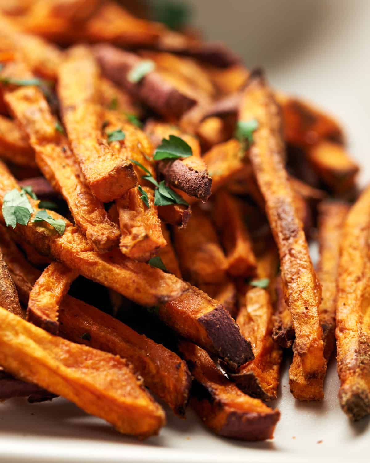 A white plate with a pile of sweet potato fries. Perfect for fish tacos. 