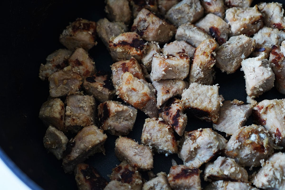 Seared cubes of pork cooked in a sauce pot.