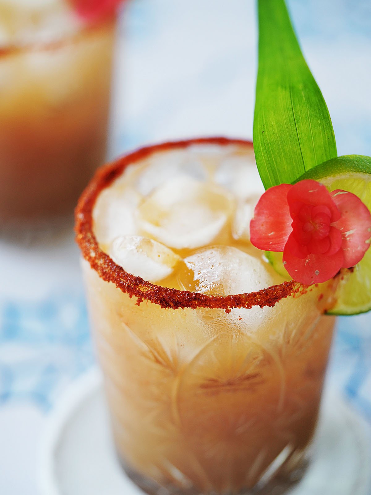 A cocktail glass with tamarind margarita garnished with a slice of lime.