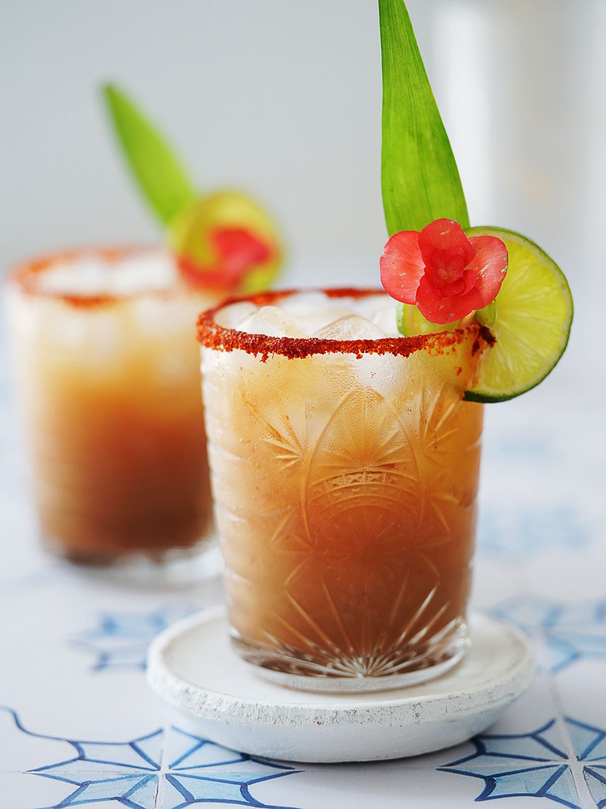 A cocktail glass with margarita de tamarindo garnished with a slice of lime.