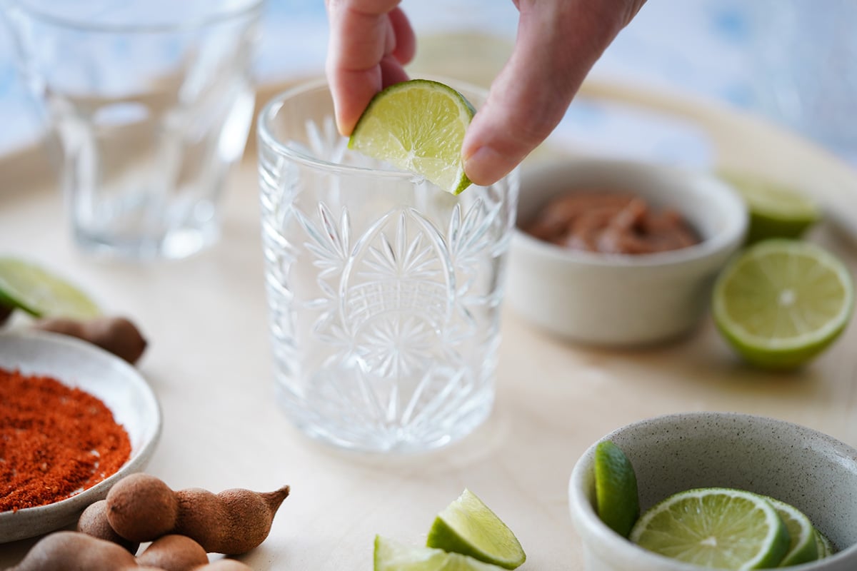 Rubbing a lime juice on the edge of a cocktail glass.